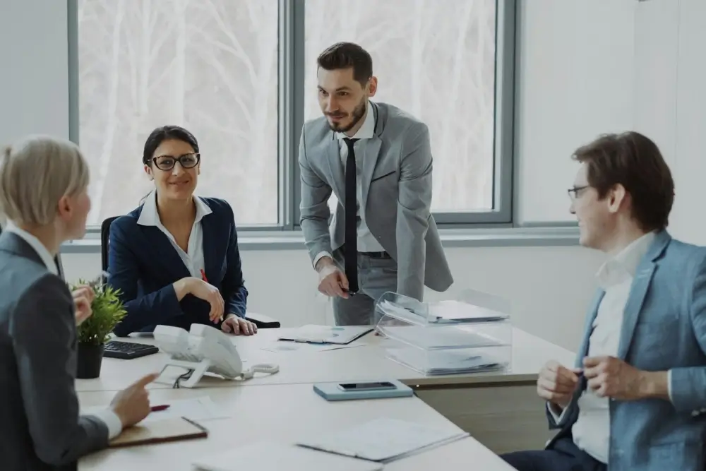 Business professional leading a team meeting while managing project goals and inspiring employee collaboration.