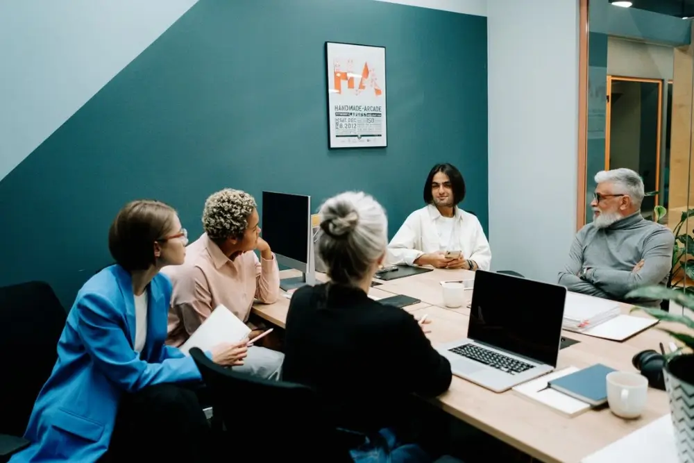 Manager guiding a diverse high-performance team in a collaborative workplace meeting