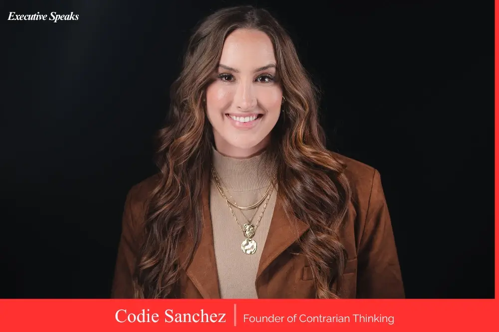 Codie Sanchez holding her book Main Street Millionaire with a stack of recommended reads on entrepreneurship and investing
