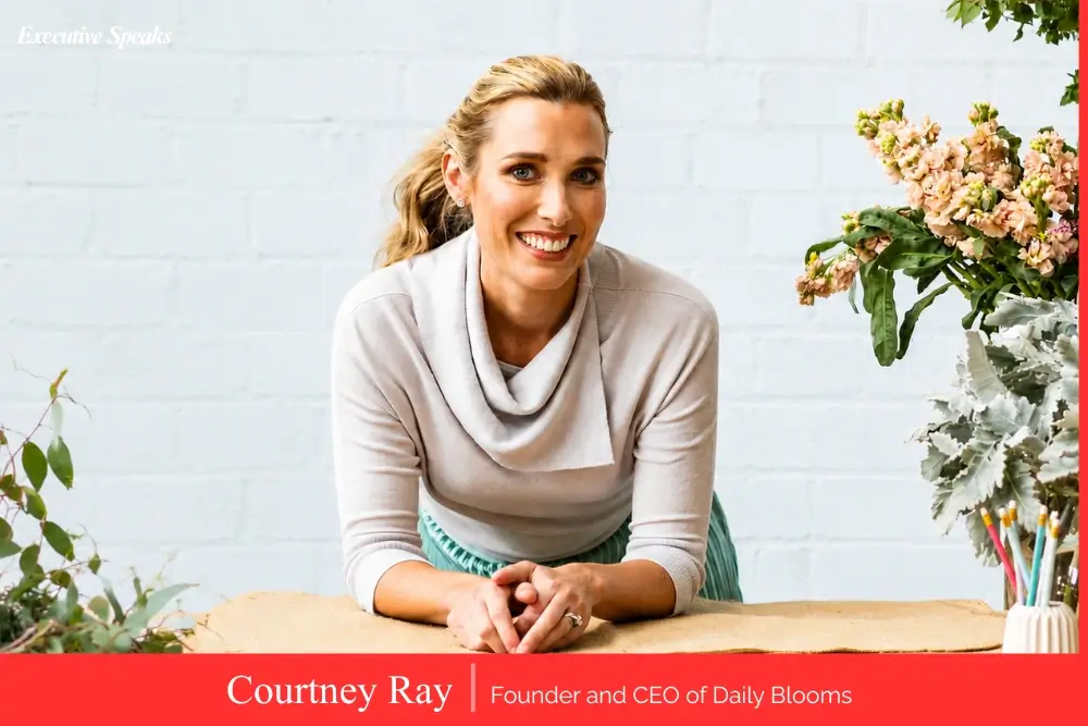 Courtney Ray, founder and CEO of Daily Blooms, surrounded by fresh flower arrangements for online delivery