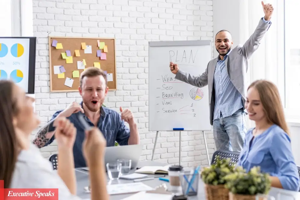 Startup founder celebrating their first customer sale and planning growth strategy on a whiteboard